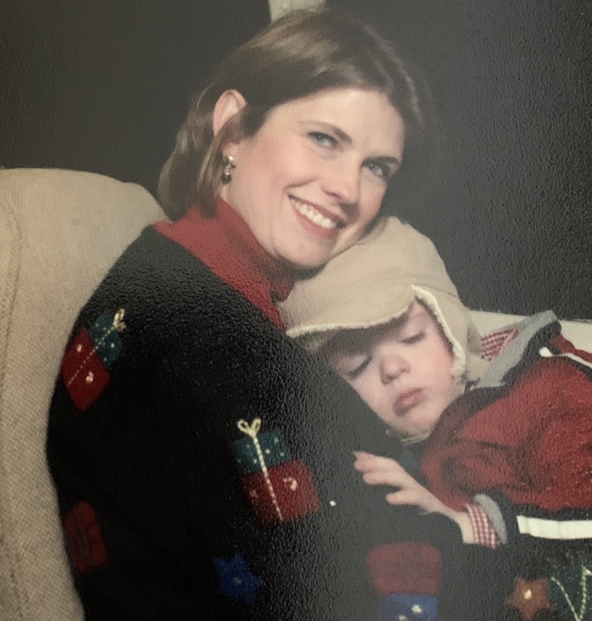 Great Smoky Mountains Railroad Polar Express Train Ride as a child tired from the excitement naps on his mom's lap