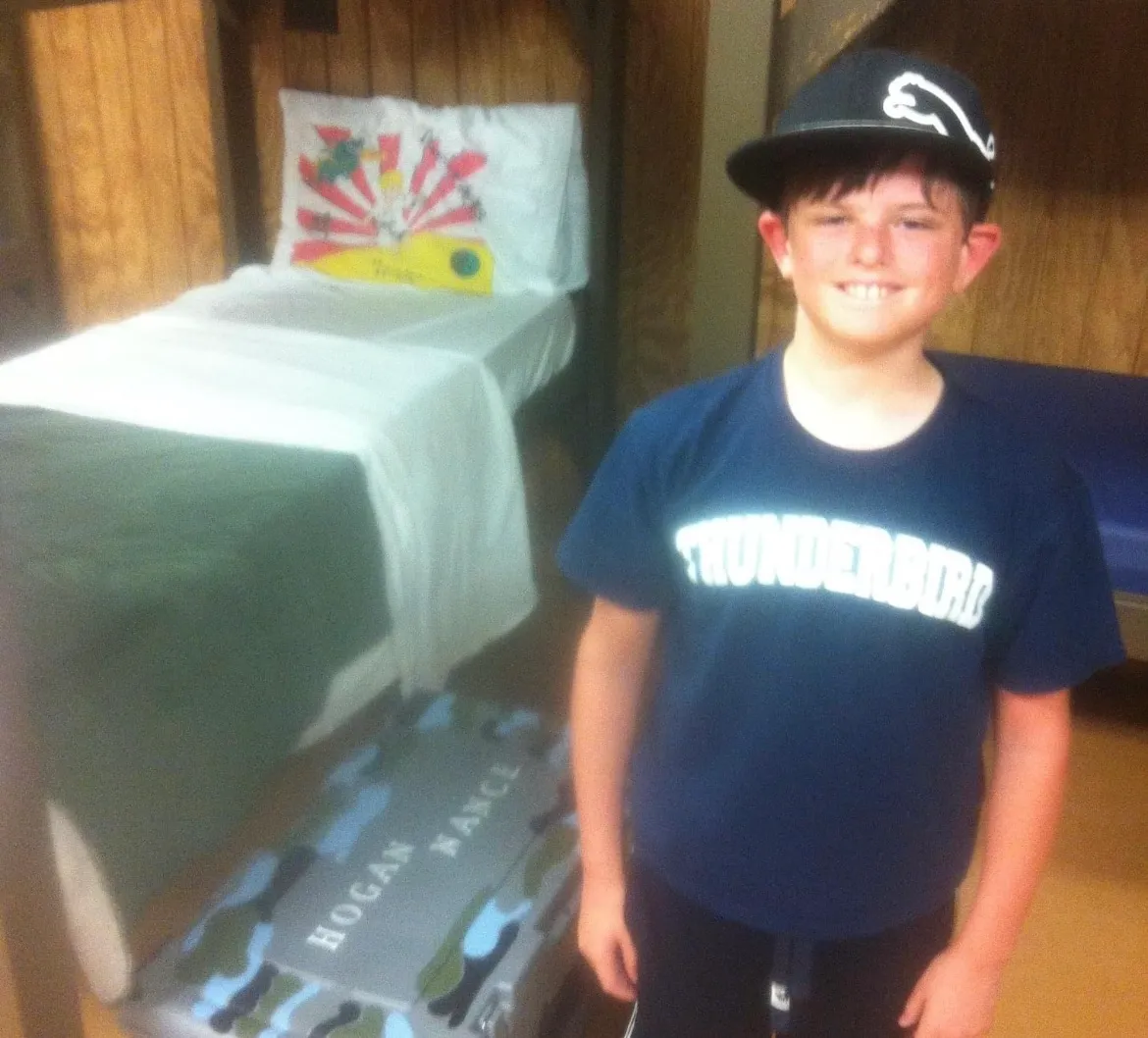 boy next to a bunk at Camp Thunderbird one of best among summer camps in the Carolinas