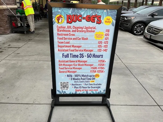 Buc-ee's South's Best Travel Stop pay and benefits sign outside a store