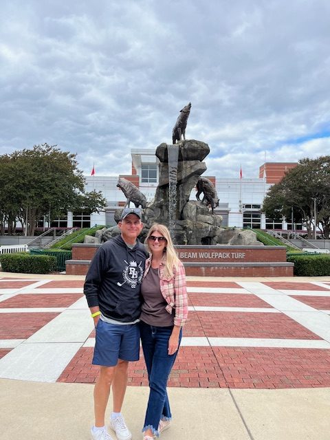 a couple standing in front of a statue at NC State in raleigh, one of the best places for quality of life in a recent study