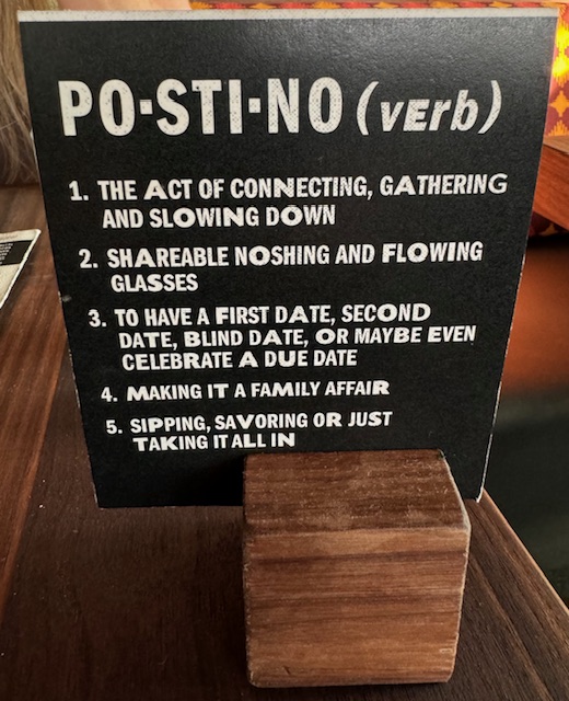 a card on a table in a restaurant describing Postino at the Bowl at Ballantyne