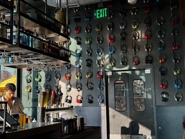 a wall of headphones on display at Postino at the Bowl at Ballantyne