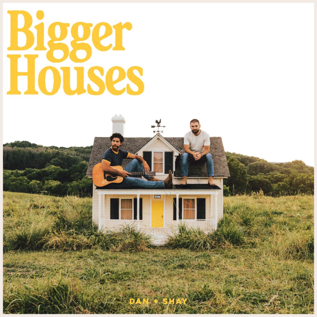 Dan + Shay's 'Bigger Houses' album covers the guys sitting outside in a field in a small house. 